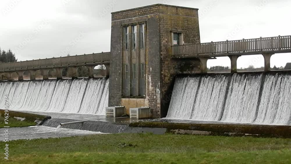 Llyn Cefni reservoir concrete dam gate overflowing from Llangefni lagoon, Anglesey rural scene Llyn Cefni reservoir concrete dam gate overflowing from Llangefni lagoon, Anglesey rural scene