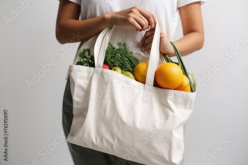 person holding reusable tote bag for shopping fruit and vegetables