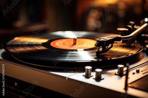 Closeup of the needle on an old record player, with the vinyl spinning in motion and a blurred background.