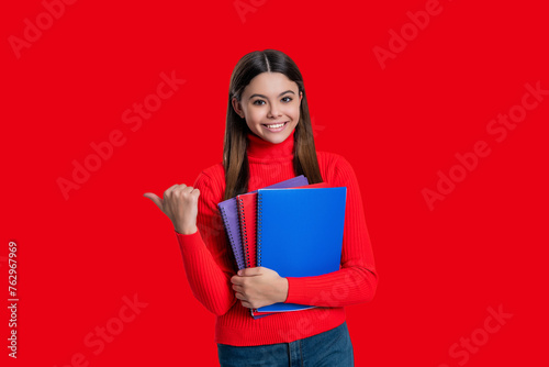 September 1. High school education. Knowledge through study. Teen girl studying with workbook. Back to school. Knowledge and education. Teen girl student isolated on red. Pointing finger