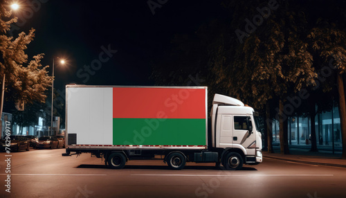 Madagascar  flag on the back of white truck against the backdrop of the city. Truck  transport  freight transport. Freight and Logistics Concept