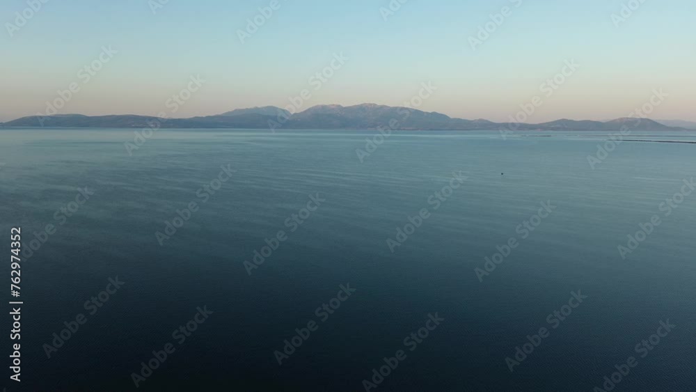 Wide ocean view panorama with mountainous coastline on the horizon. Aerial dolly in, rise up. Wide ocean view panorama with mountainous coastline on the horizon. Aerial dolly in, rise up.