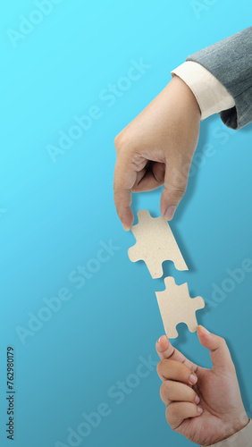 Closeup view of business hand put puzzle pieces together for unity and teamwork
