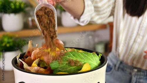 Woman pouring bokashi fermentation starter in a compost bin with organic food waste. Responsible woman recycling leftovers into natural fertilizer. Ecological and sustainability concept photo