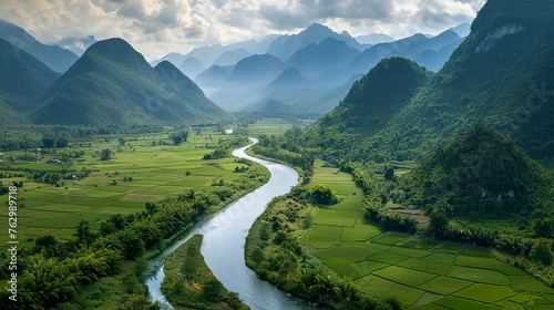 A winding river cutting through a lush valley © Photock Agency