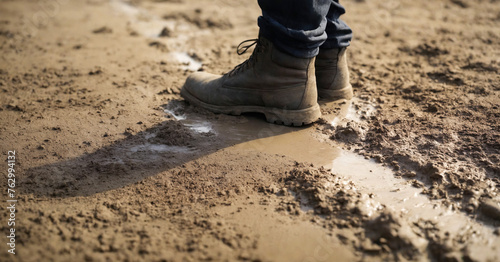 Man stands in dirty boots in the mud