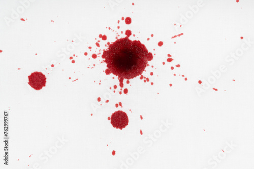 Drops of blood stains on white fabric. blood splatters on clothes. red dripping blood spatters photo