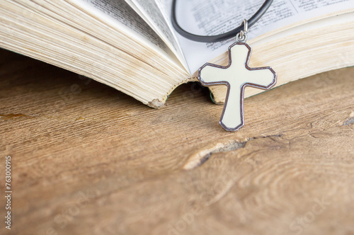 Closeup christian cross and bible on old wooden table with sunlight. christian concept Jesus is the light of the world