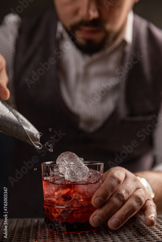 Bartender pouring cocktail at bar
