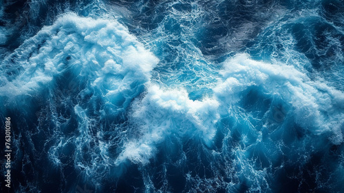 beautiful photo of blue water flowing in waves with white foam in a ocean. taken from up top above perspective. wallpaper background  photo
