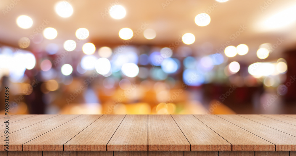 Empty wooden table top with lights bokeh on blur restaurant background. Empty wooden table top with lights bokeh on blur restaurant background.