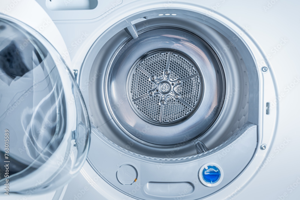 Inside of tumble dryer with clean laundry - new generation of heat pump dryer, household concept