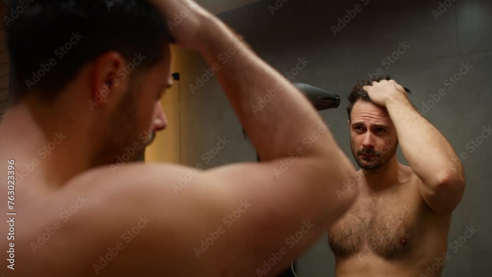 Caucasian man drying hair with a hairdryer Caucasian man drying hair with a hairdryer