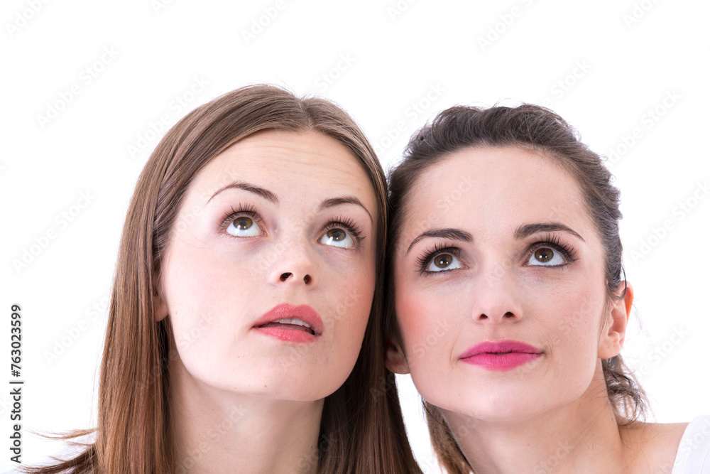 Two beautiful women looking upwards above there heads. Two beautiful women looking upwards above there heads.