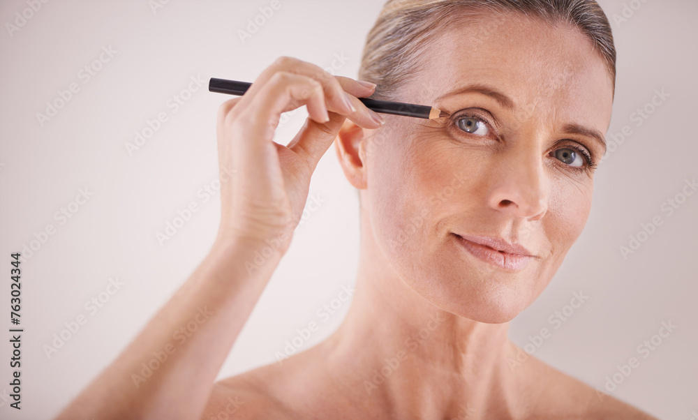 Cosmetics, portrait and woman with eyeliner in studio for beauty, natural and self care routine. Makeup, senior and female person with cosmetology product for facial treatment by white background. Cosmetics, portrait and woman with eyeliner in studio for beauty, natural and self care routine. Makeup, senior and female person with cosmetology product for facial treatment by white background.