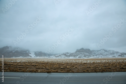 Hainan Mongolian and Tibetan Autonomous Prefecture, Qinghai Province-Grasslands and roads under the snow-capped mountains photo