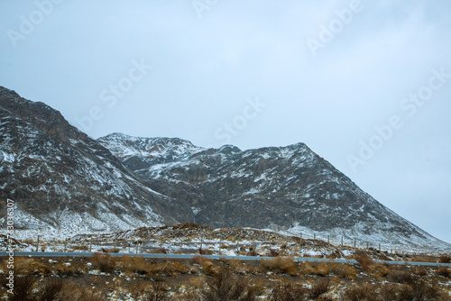 Hainan Mongolian and Tibetan Autonomous Prefecture, Qinghai Province-Grasslands and roads under the snow-capped mountains photo