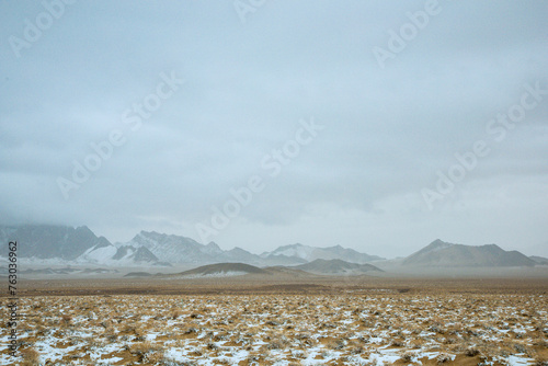 Hainan Mongolian and Tibetan Autonomous Prefecture, Qinghai Province-Grasslands and roads under the snow-capped mountains photo