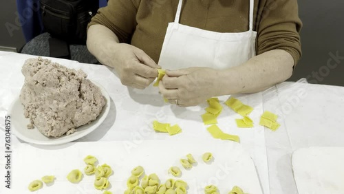Woman pasta maker preparing artisanal tortellini. Production area Modena, Italy.
