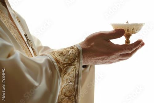 Detail of the hand of a priest in communion with a host consecrated as the body of Christ with a white isolated background photo