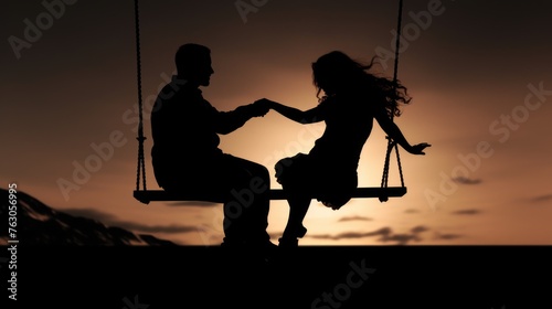 A romantic silhouette of a couple on a swing. Perfect for love and relationship concepts