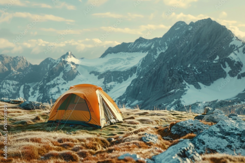 A tent pitched up on a grassy hill with mountains in the background. Ideal for outdoor adventure and camping concepts