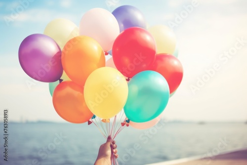 Person holding a bunch of colorful balloons, perfect for festive occasions