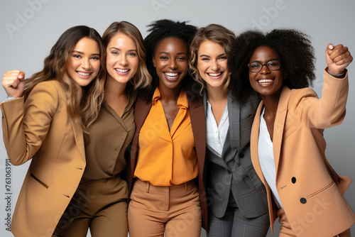 Portrait of international girls in business suits on a gray background.