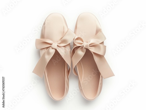 Top view of stylish pink ballet shoes with ribbon bows on a white background, symbolizing fashion and femininity