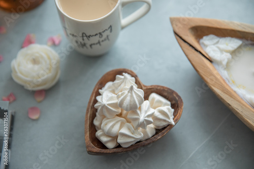 A portion of meringue in a small wooden plate in the shape of a heart