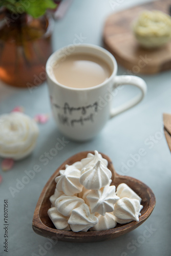 A portion of meringue in a small wooden plate in the shape of a heart