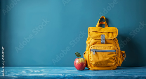 sac à dos d'écolier posé à côté d'une pomme pour le goûter photo