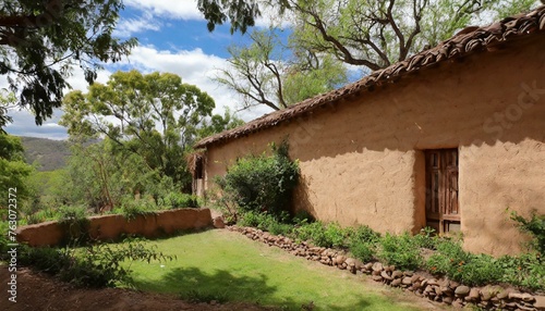 Adobe house wall with a garden full of trees behind it