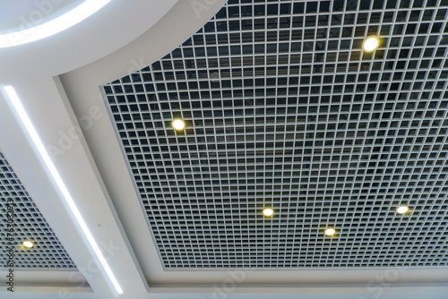 Beautiful ceiling and lighting design in a modern shopping mall. Wooden paneling on the ceiling and large round lamps.