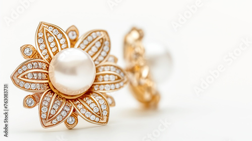 A pair of earrings with a flower design and a pearl in the center