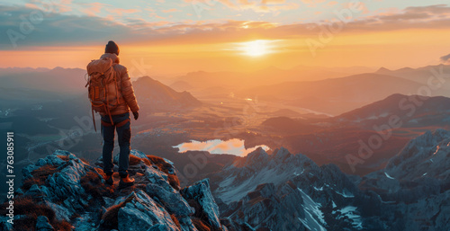 Hiker at the summit of a mountain overlooking a stunning landscape