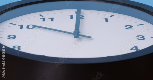 4K footage front view CU Time-lapse,  black wall clock Started telling time at 09.45 o'clock. photo