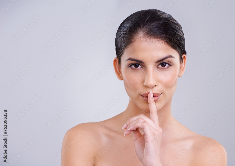 Woman, finger to lips and secret for beauty with portrait, cosmetic care and wellness with silent gesture on grey background. Dermatology, skincare and whisper with emoji, selfcare and natural glow Woman, finger to lips and secret for beauty with portrait, cosmetic care and wellness with silent gesture on grey background. Dermatology, skincare and whisper with emoji, selfcare and natural glow