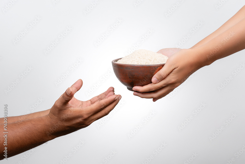 Closeup Hands giving bowl of rice for zakat fitrah. Concept of alms, food sharing and help each other. Closeup Hands giving bowl of rice for zakat fitrah. Concept of alms, food sharing and help each other.