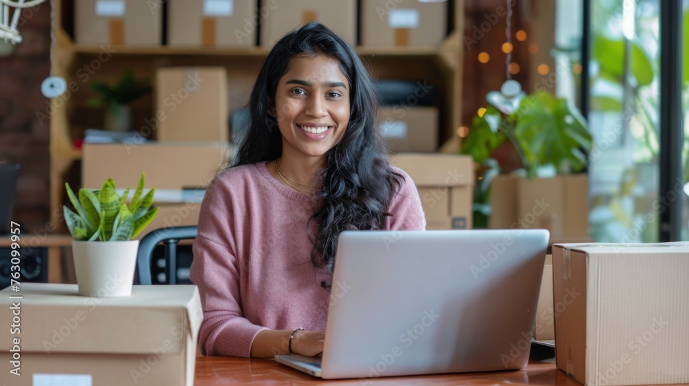 Small business owner is working on a laptop in the warehouse Small business owner is working on a laptop in the warehouse