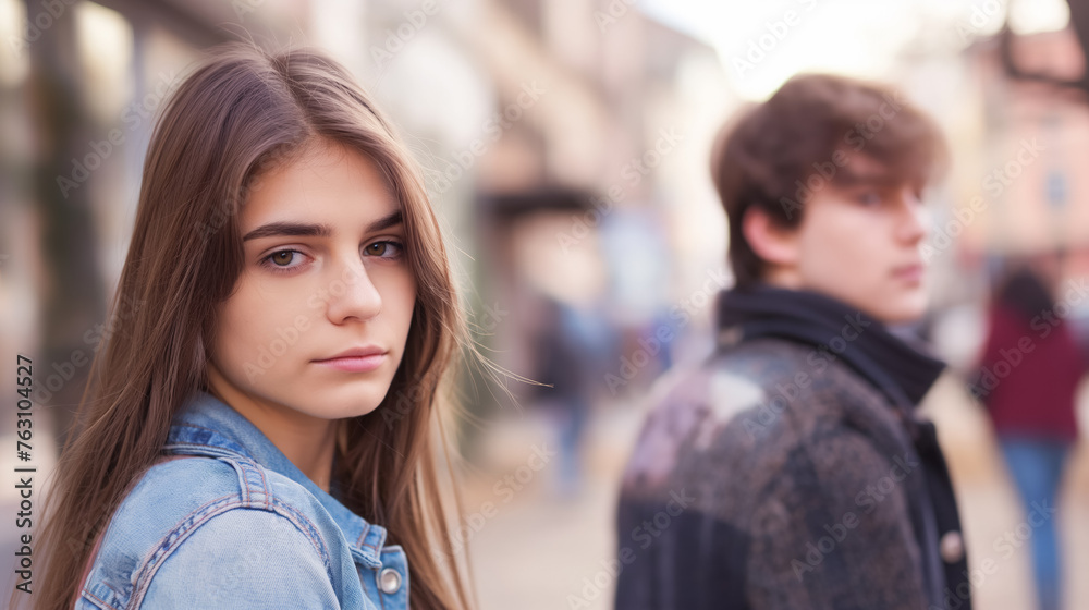 Girl in focus with a boy out of focus behind.