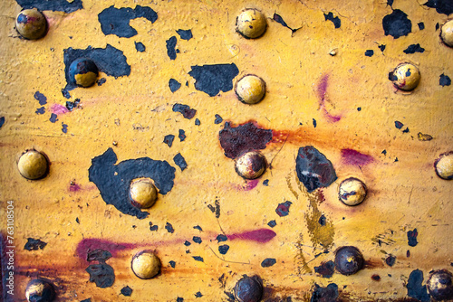 Old Rusty Metal Surface with Bolts and Peeling Yellow Paint