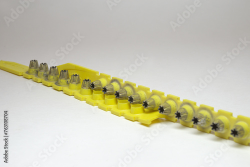 powder actuated tool loads. spent and new cartridges, inserted into pair of yellow strips. selective focus