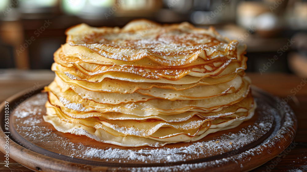 Stack of freshly made crepes dusted with powdered sugar on a wooden plate with a rustic kitchen background. Stack of freshly made crepes dusted with powdered sugar on a wooden plate with a rustic kitchen background.