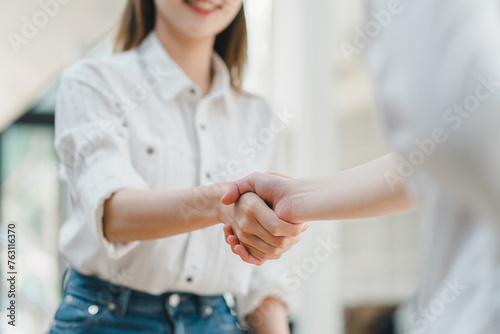 Close-up of a warm  friendly handshake between two professionals in a bright  casual setting  signaling a positive agreement.