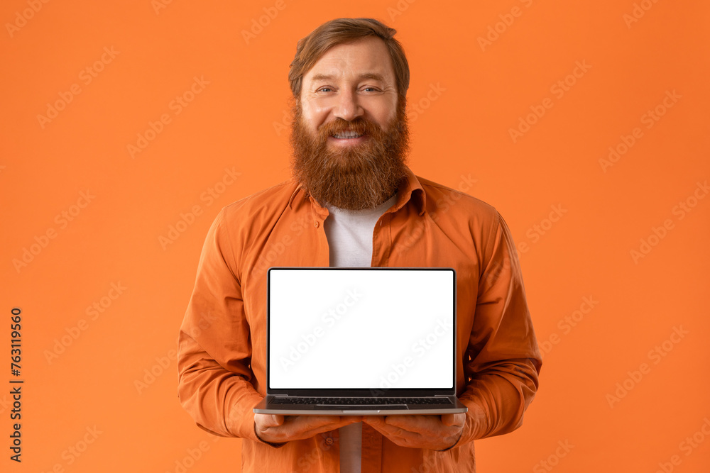 Smiling Redhaired Bearded Man Holding Laptop With Blank Screen, Studio Smiling Redhaired Bearded Man Holding Laptop With Blank Screen, Studio