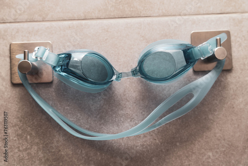 Swimming goggles displayed on a hook in the shower room interior