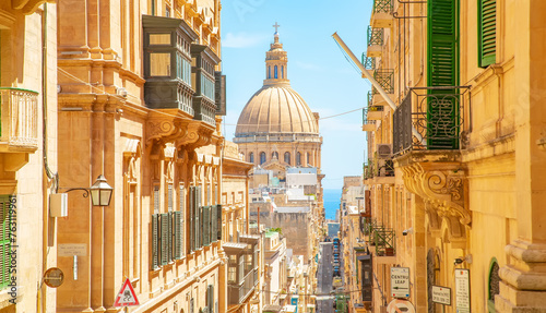 Sunny street in Valletta old town, St Paul’s Anglican Pro-Cathedral on a background photo