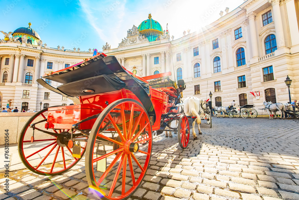 Hofburg palace and horse carriage on sunny Vienna street