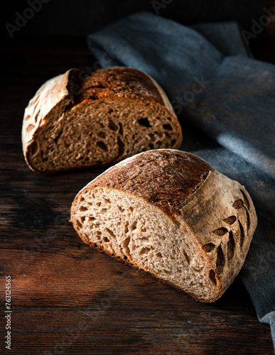 Homemade sourdough bread. Fresh Sourdough bread cut in half, on a black background. 